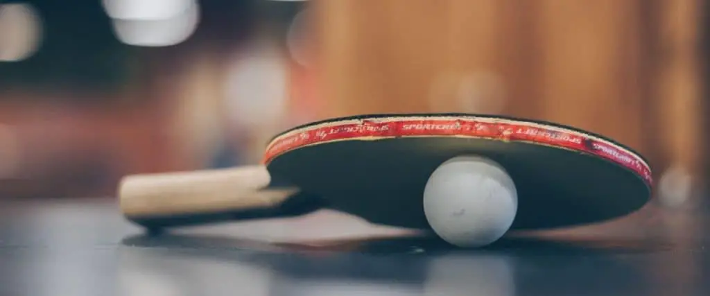 Tischtennisschläger liegt auf einem Ball