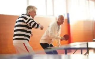Two elderly men playing table tennis